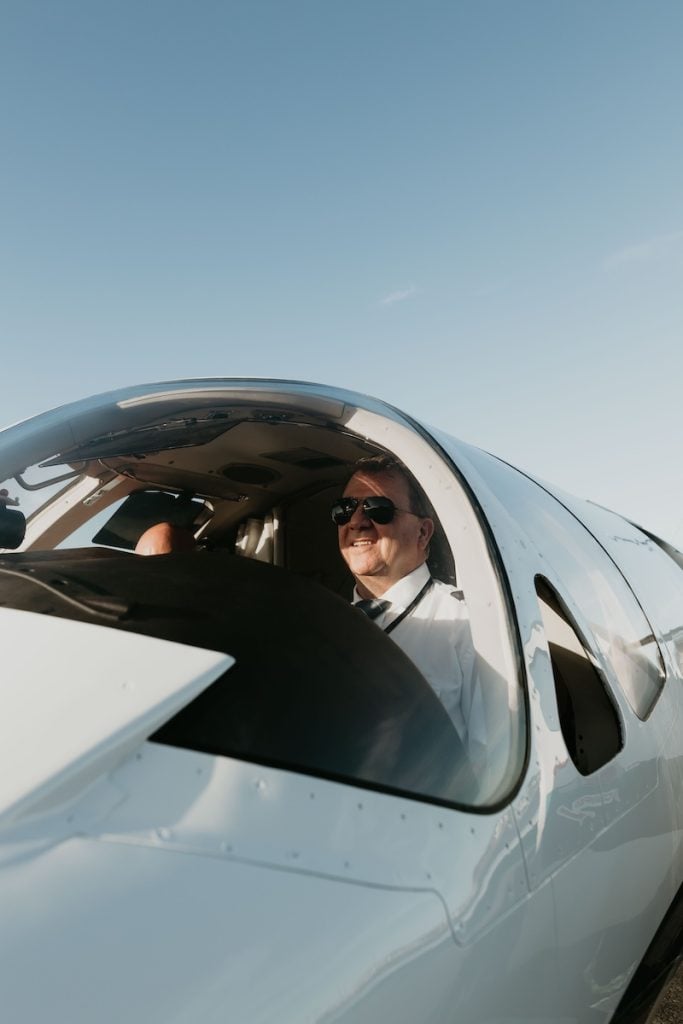 Pilot in cockpit of a small airplane.