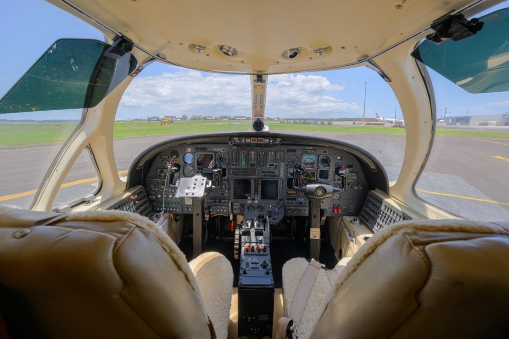 Aircraft cockpit view, runway ahead, clear skies.