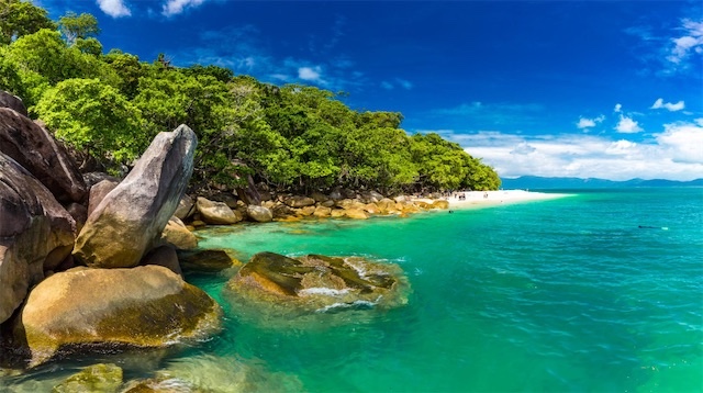 Tropical beach paradise with turquoise water and lush greenery.