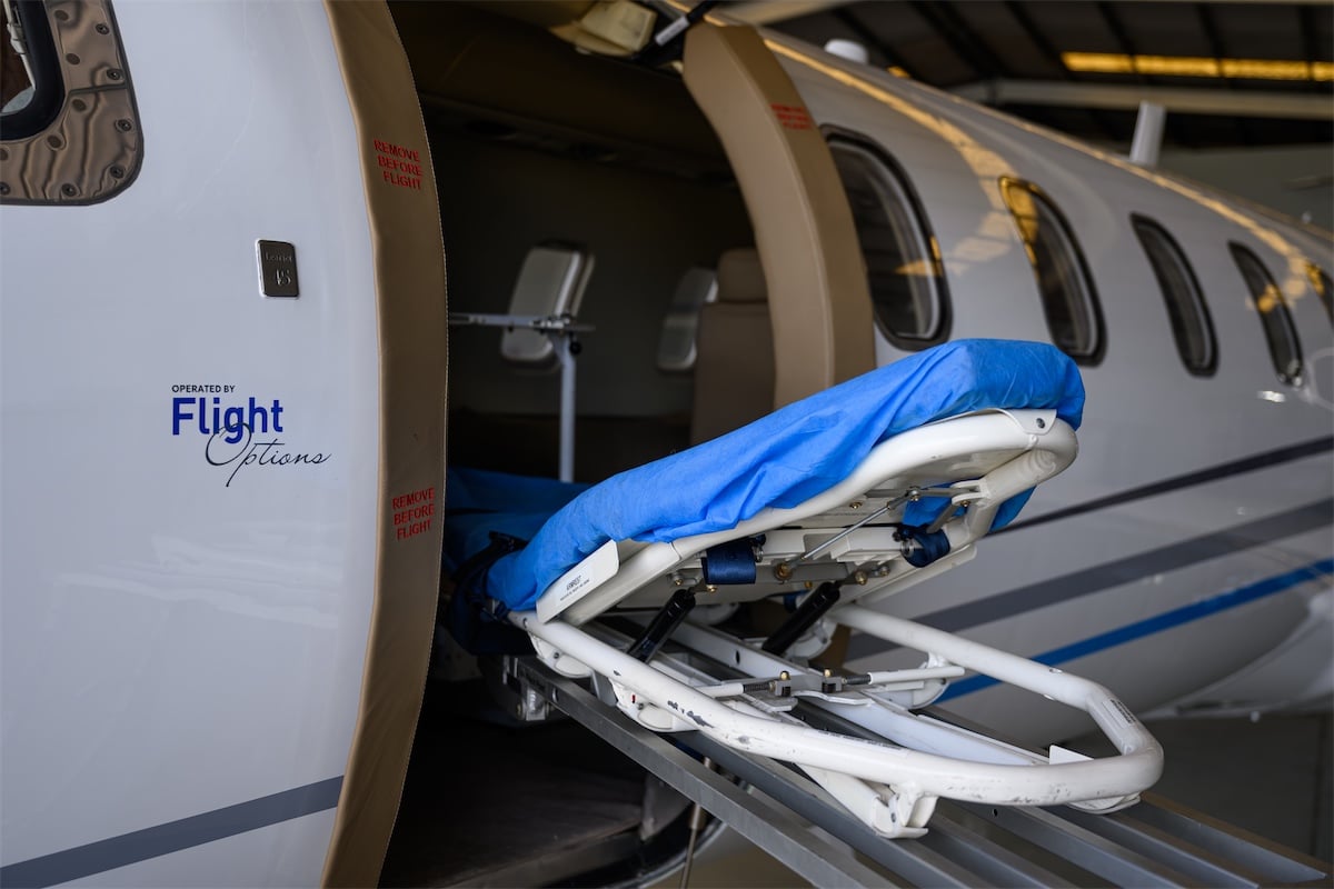 Medical stretcher entering Flight Options airplane as part of an aeromedical transfer.