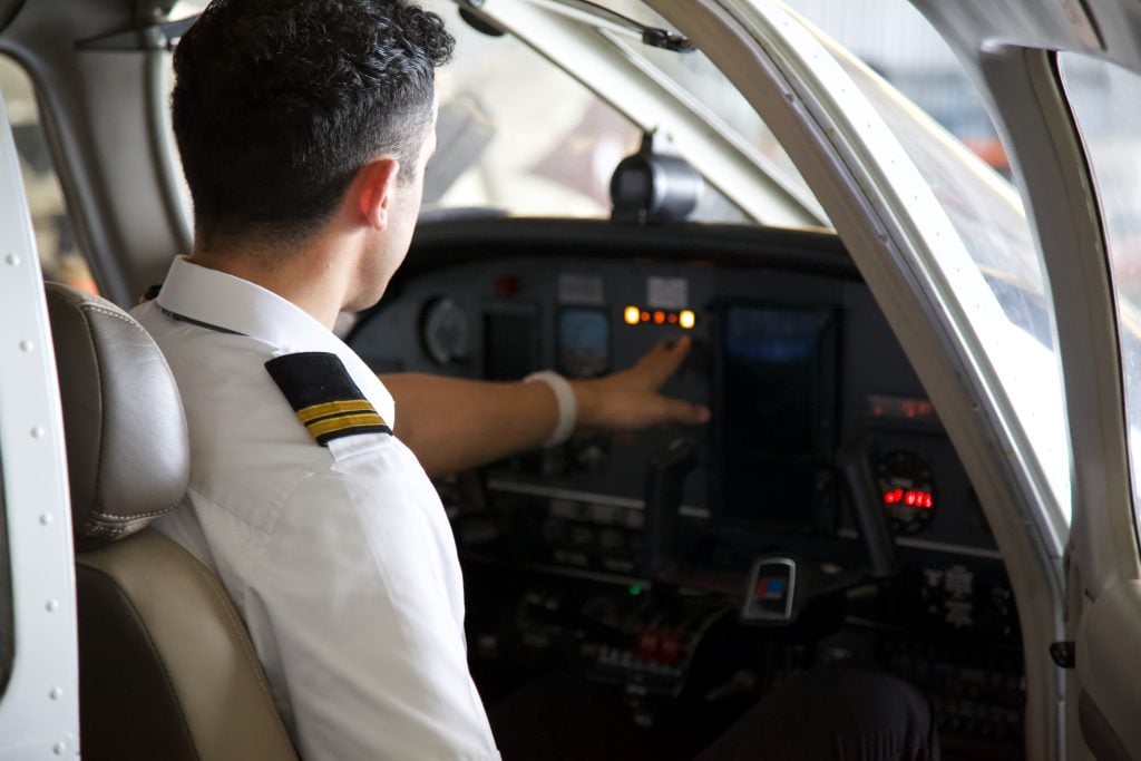 Pilot in cockpit checks airplane instruments