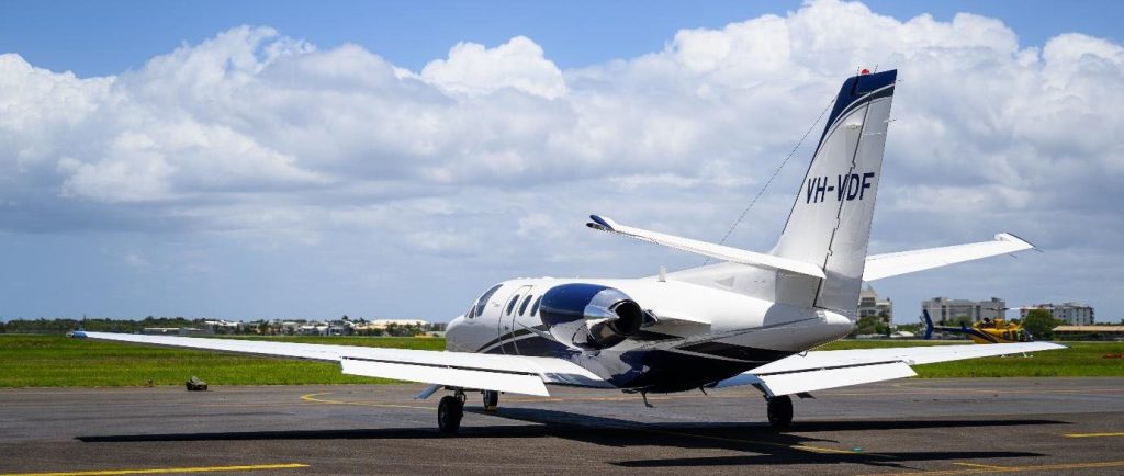 White and blue private jet on runway